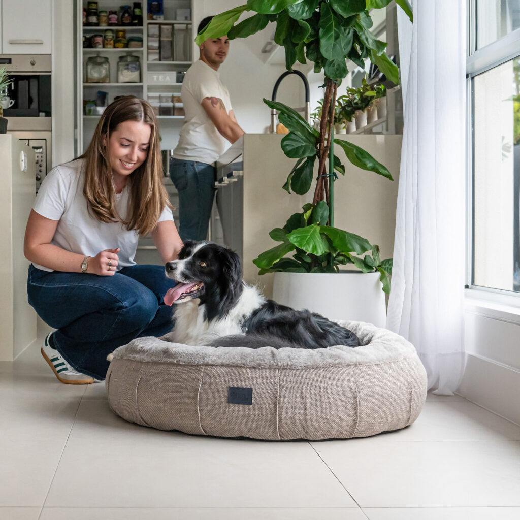 Round dog bed with raised walls and faux fur calming lining in light brown puppachino colour